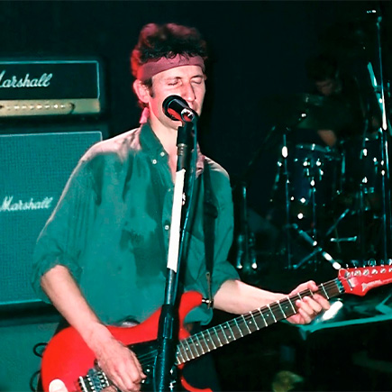 Skay con los ojos cerrados tocando la guitarra
