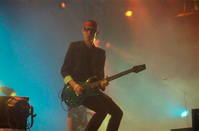 Skay mirando a camara tocando la guitarra en el recital